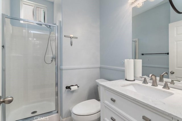 full bathroom with a stall shower, vanity, and toilet