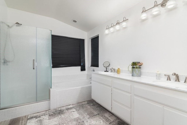 full bath with lofted ceiling, a stall shower, a sink, and a garden tub