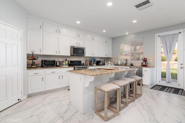 kitchen with white cabinetry, visible vents, appliances with stainless steel finishes, and backsplash