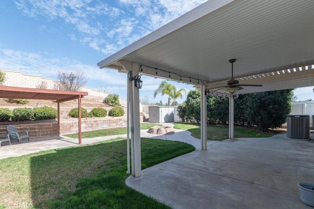 view of yard featuring central AC unit, a patio area, ceiling fan, a shed, and an outdoor structure