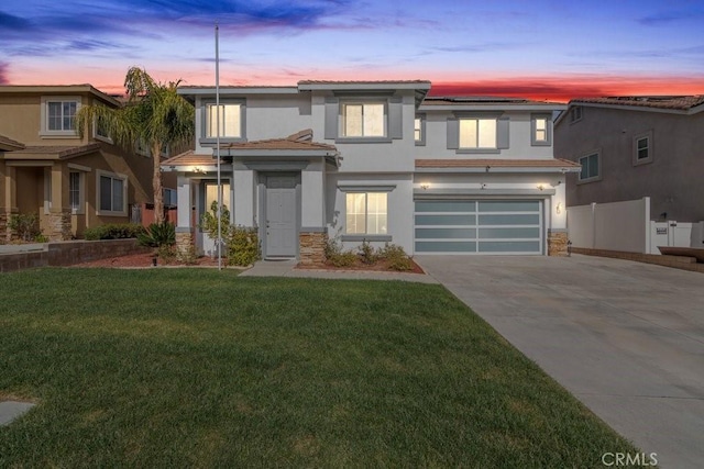 view of front of home with fence, stone siding, concrete driveway, stucco siding, and a front lawn