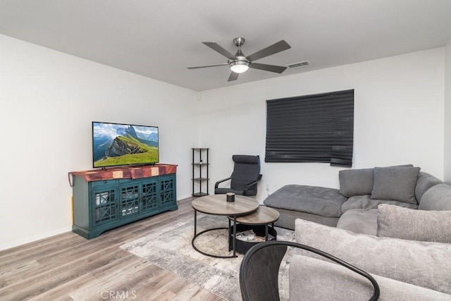 living room featuring baseboards, ceiling fan, visible vents, and wood finished floors