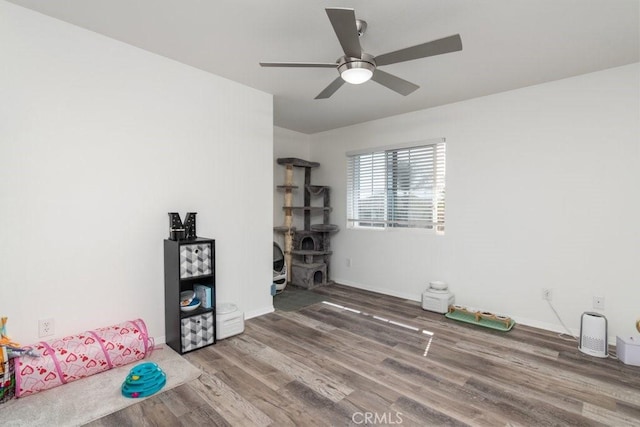 miscellaneous room with a ceiling fan, baseboards, and wood finished floors