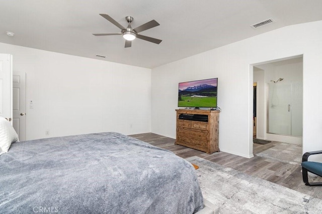 bedroom featuring a ceiling fan, visible vents, and wood finished floors