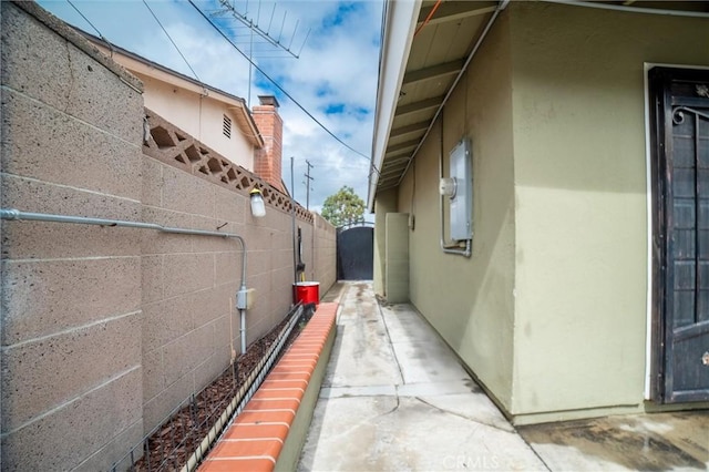 view of side of property with stucco siding and fence