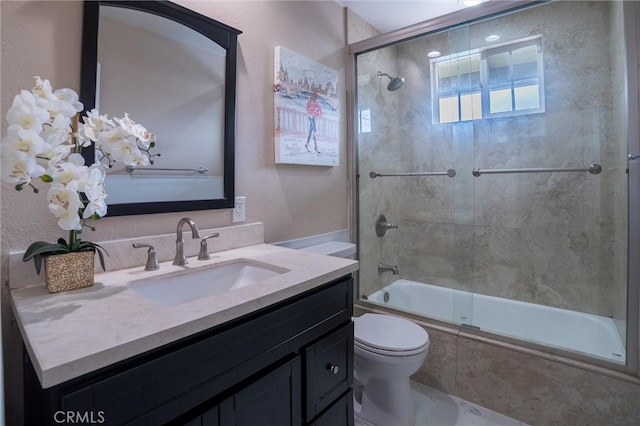 bathroom featuring vanity, toilet, and bath / shower combo with glass door