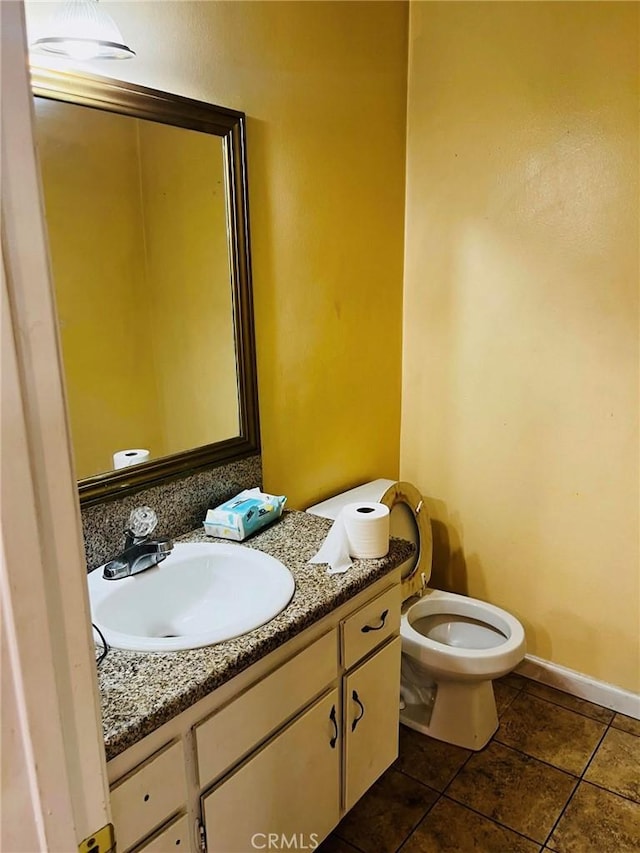 bathroom featuring tile patterned flooring, baseboards, vanity, and toilet