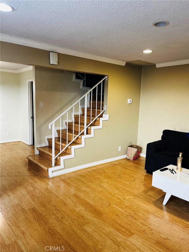 interior space featuring ornamental molding, stairway, and wood finished floors