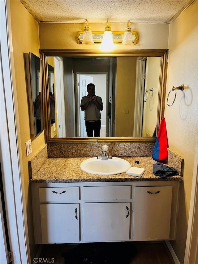 bathroom with a textured ceiling and vanity