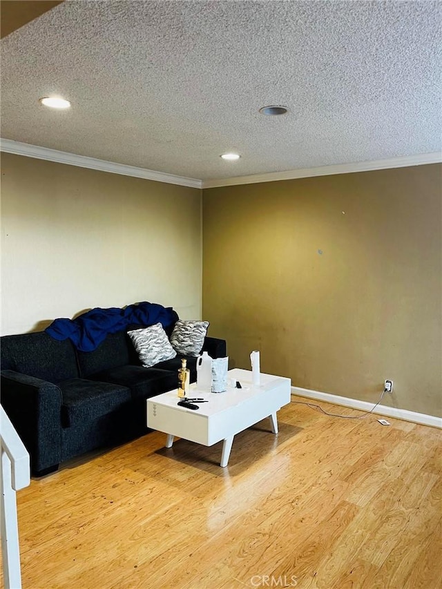 living area featuring a textured ceiling, light wood finished floors, and crown molding