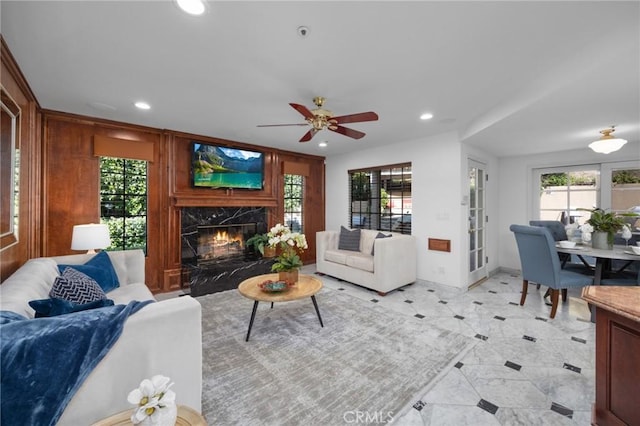 living room with plenty of natural light, recessed lighting, a fireplace, and wood walls