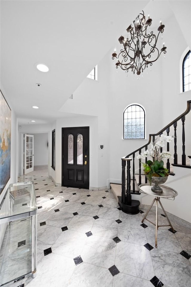 foyer featuring baseboards, a high ceiling, stairs, a notable chandelier, and recessed lighting