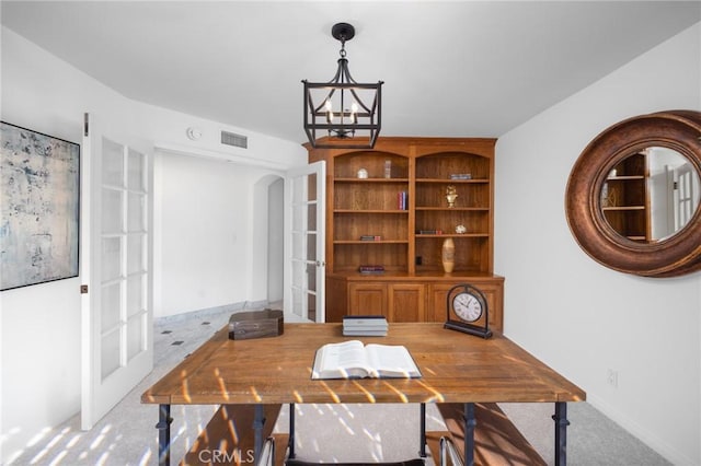 carpeted office featuring a chandelier, arched walkways, french doors, and visible vents