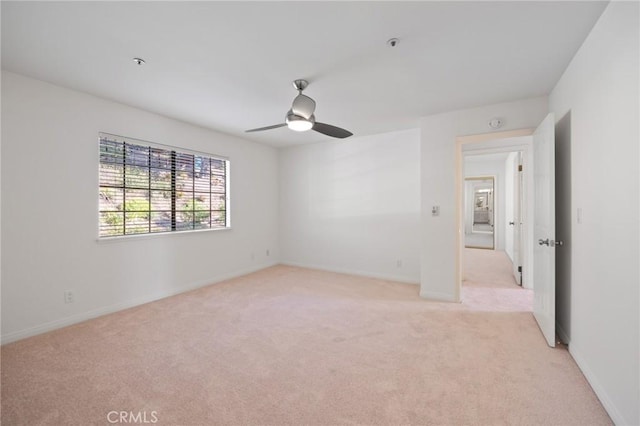 empty room with light carpet, ceiling fan, and baseboards