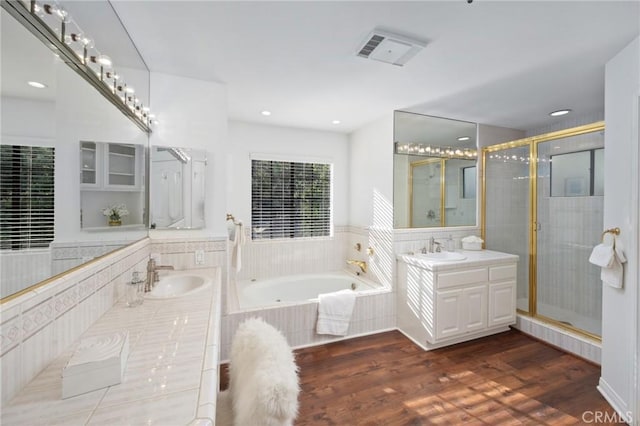 full bathroom with a garden tub, wood finished floors, a stall shower, and a sink