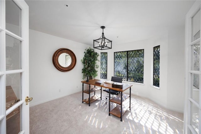 office space featuring light colored carpet, baseboards, and an inviting chandelier