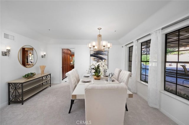 dining space featuring a chandelier, baseboards, visible vents, and light colored carpet