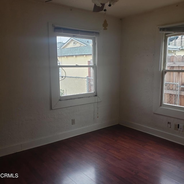 empty room featuring dark wood-style floors and baseboards
