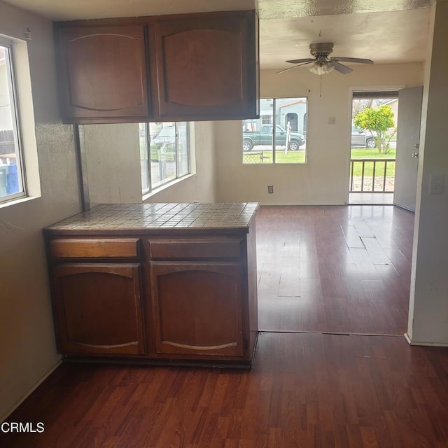 kitchen featuring a ceiling fan, tile countertops, and dark wood-style floors