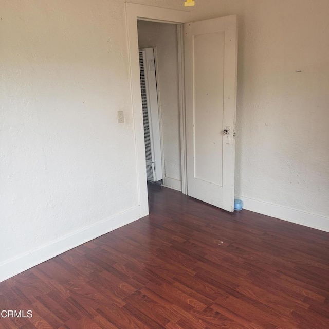 unfurnished room featuring wood finished floors and baseboards