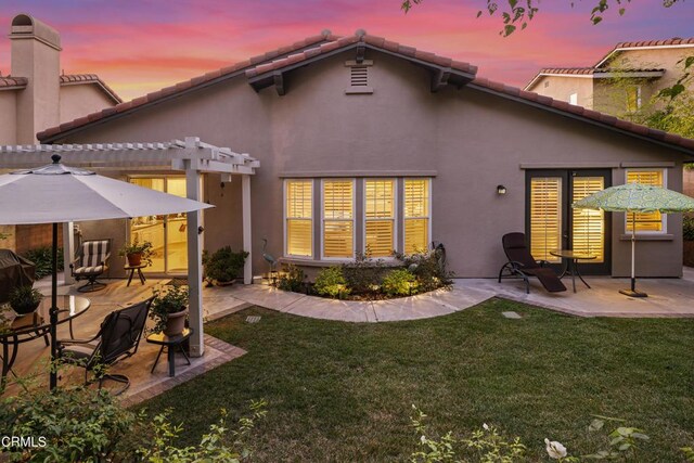 rear view of property with a patio, a lawn, and a pergola