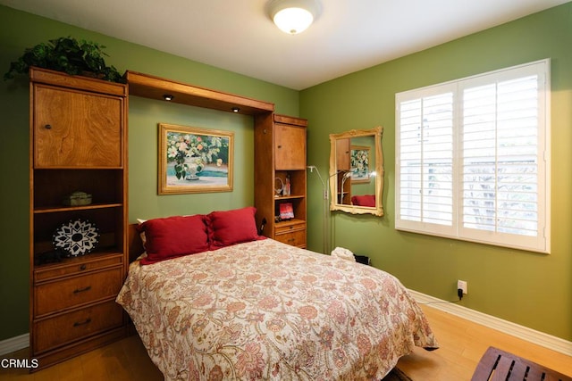 bedroom with baseboards and wood finished floors