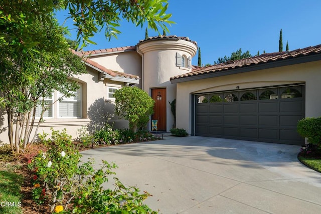 mediterranean / spanish-style house with a garage, a tiled roof, concrete driveway, and stucco siding