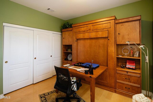 office area featuring light wood-style flooring and visible vents