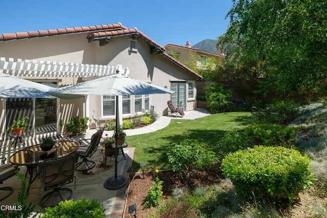 back of house featuring stucco siding, a yard, a pergola, and a patio