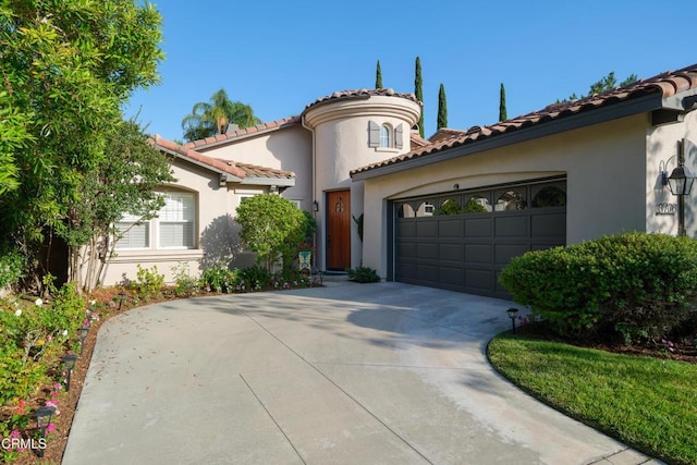 mediterranean / spanish-style home featuring an attached garage, driveway, a tile roof, and stucco siding