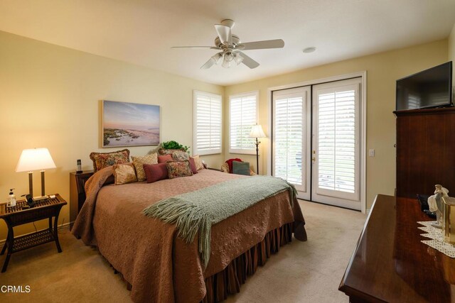 bedroom with a ceiling fan, light colored carpet, and access to exterior