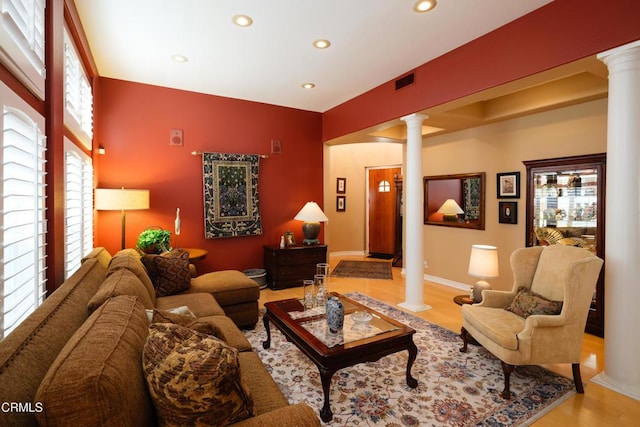 living area featuring light wood-style floors, decorative columns, baseboards, and recessed lighting