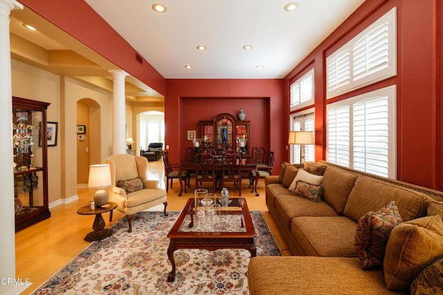 living area with arched walkways, decorative columns, recessed lighting, visible vents, and wood finished floors