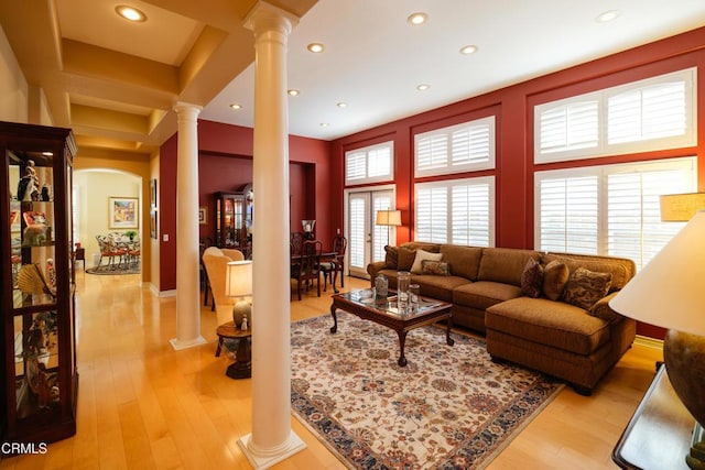 living area with light wood-style floors, recessed lighting, and decorative columns