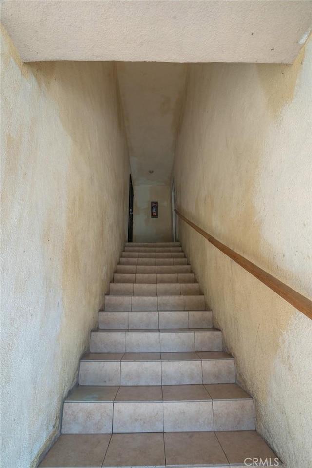 stairway featuring tile patterned flooring