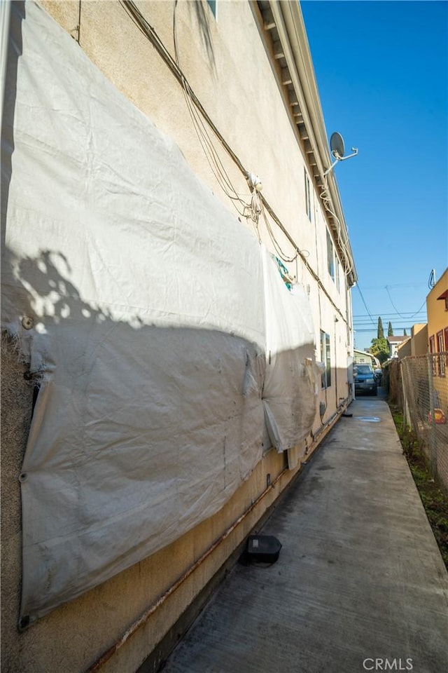 view of property exterior featuring fence and stucco siding