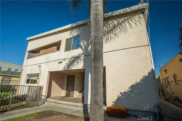 back of property with fence and stucco siding