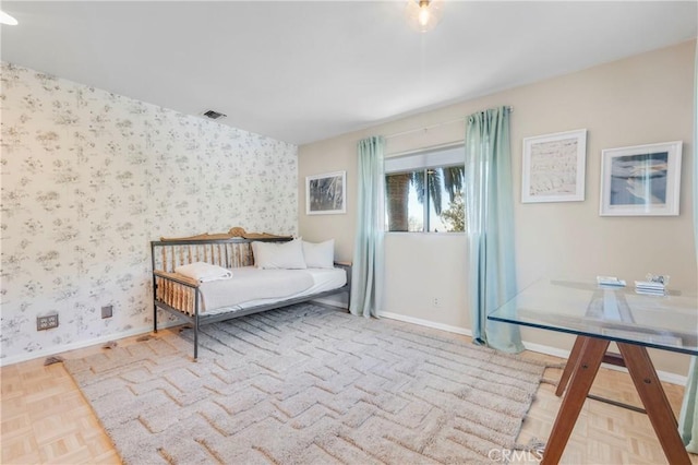 bedroom with baseboards, visible vents, and wallpapered walls