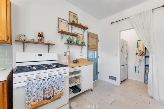 kitchen featuring white appliances, tasteful backsplash, visible vents, light countertops, and open shelves