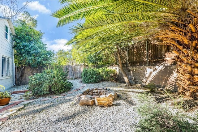 view of yard with an outdoor fire pit and fence