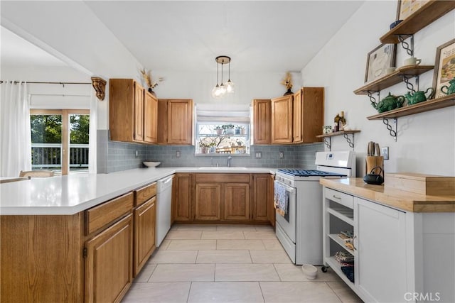 kitchen with open shelves, white appliances, a peninsula, and a sink