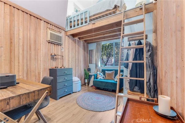 office area featuring an AC wall unit, wooden walls, and wood finished floors