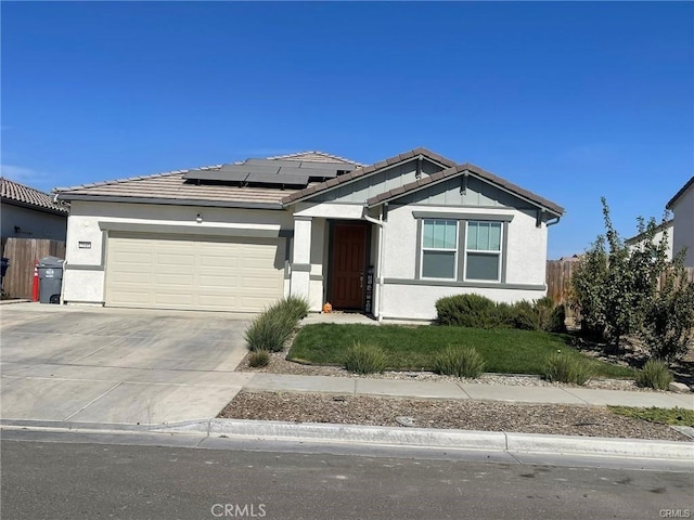 ranch-style home with stucco siding, concrete driveway, an attached garage, roof mounted solar panels, and fence