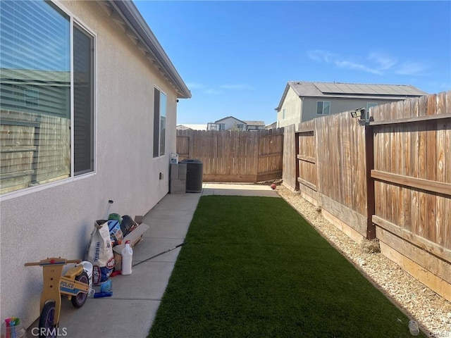 view of yard with central AC and a fenced backyard