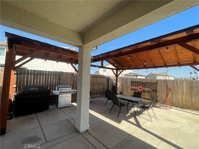 view of patio featuring fence, grilling area, and outdoor dining space