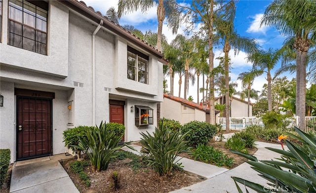 view of front of house featuring fence and stucco siding