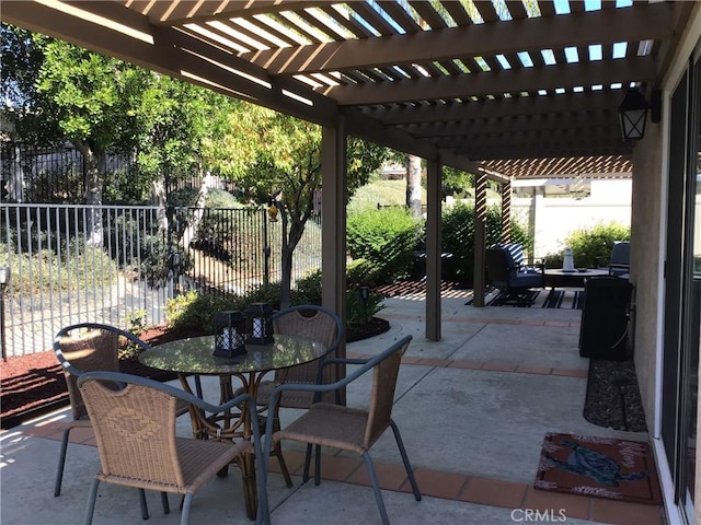 view of patio featuring outdoor dining space, fence, and a pergola