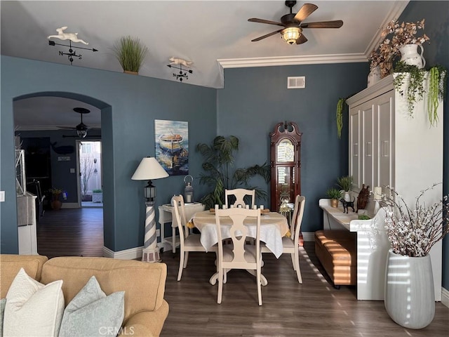 dining area featuring ornamental molding, arched walkways, visible vents, and dark wood-style floors