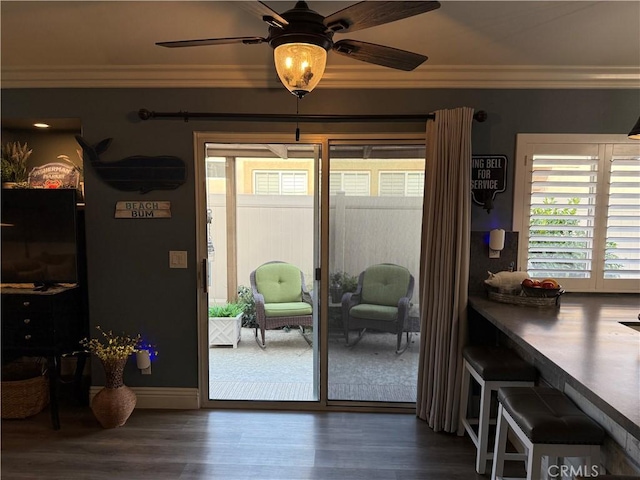 doorway to outside with ceiling fan, crown molding, and wood finished floors