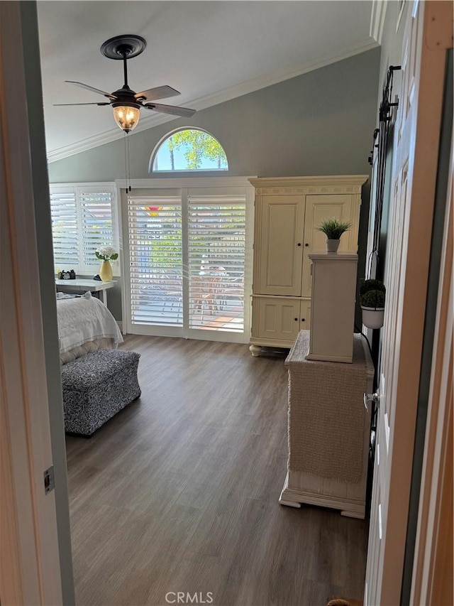 interior space featuring wood finished floors, ceiling fan, crown molding, and lofted ceiling